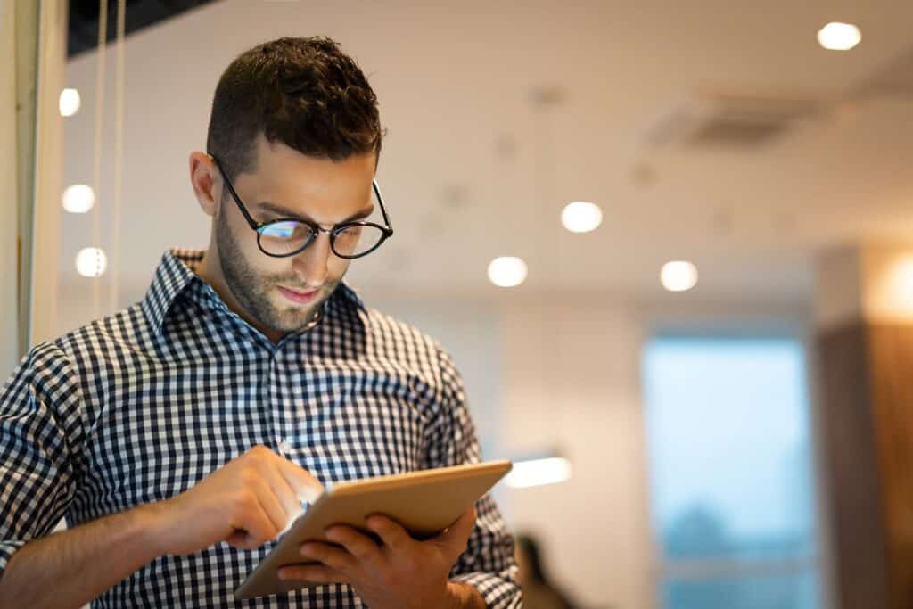 Portrait of Confident Businessman using tablet at office