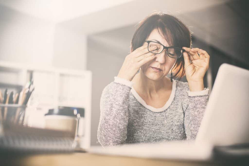 woman rubbing eyes min